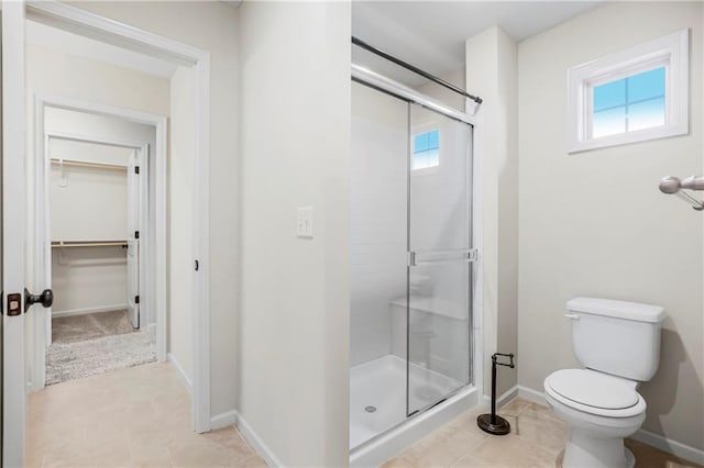 bathroom featuring tile patterned floors, toilet, and an enclosed shower