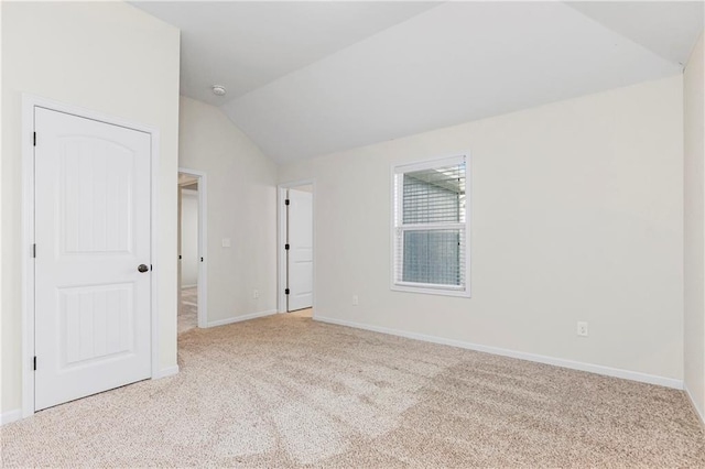 carpeted spare room featuring lofted ceiling