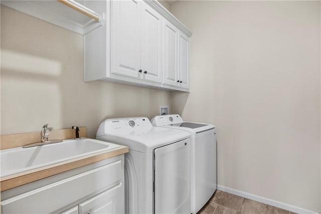 washroom with cabinets, separate washer and dryer, and sink