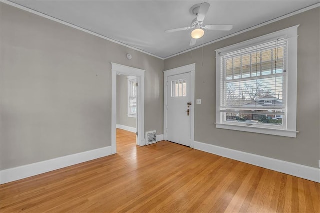 entryway featuring ornamental molding, light hardwood / wood-style floors, ceiling fan, and a healthy amount of sunlight