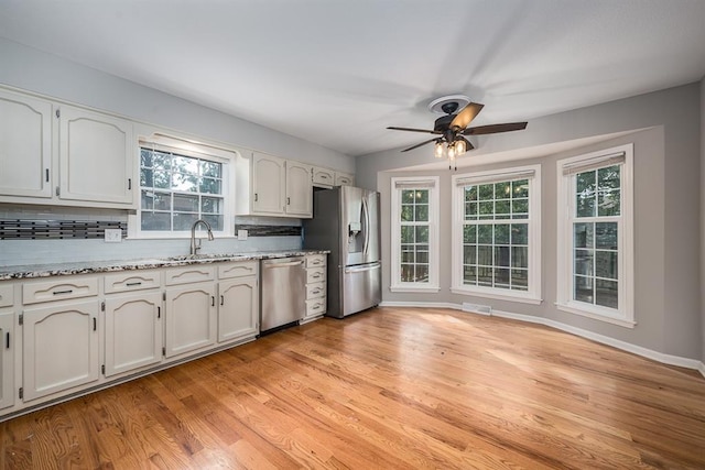 kitchen with sink, white cabinets, appliances with stainless steel finishes, and decorative backsplash