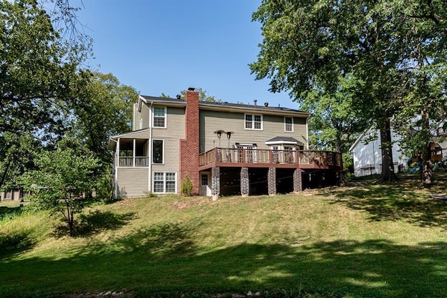 back of house featuring a wooden deck, a lawn, a chimney, and a sunroom