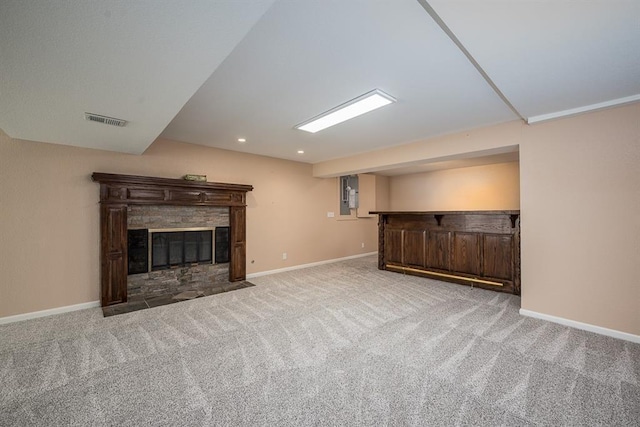 unfurnished living room with visible vents, a fireplace with flush hearth, baseboards, and carpet