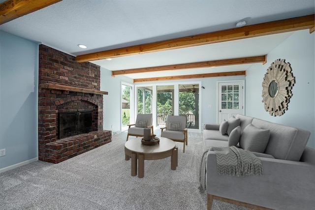 carpeted living room with beamed ceiling, a fireplace, baseboards, and a textured ceiling