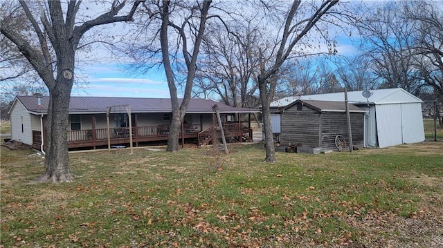423 Elm St, Mound City, KS 66056 - back of house featuring a yard, an outbuilding, and a deck