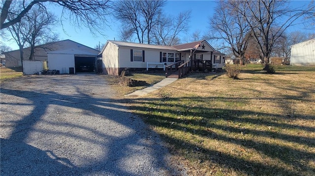 423 Elm St, Mound City, KS 66056 - view of front facade featuring a porch, a front lawn, and an outdoor structure