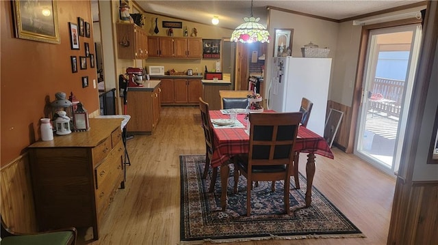 423 Elm St, Mound City, KS 66056 - dining space featuring light hardwood / wood-style floors, lofted ceiling, and ornamental molding