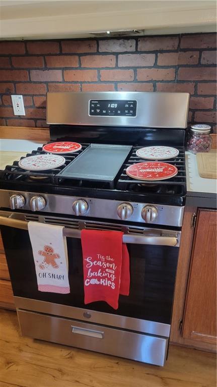 423 Elm St, Mound City, KS 66056 - details featuring light wood-type flooring and stainless steel range with gas stovetop