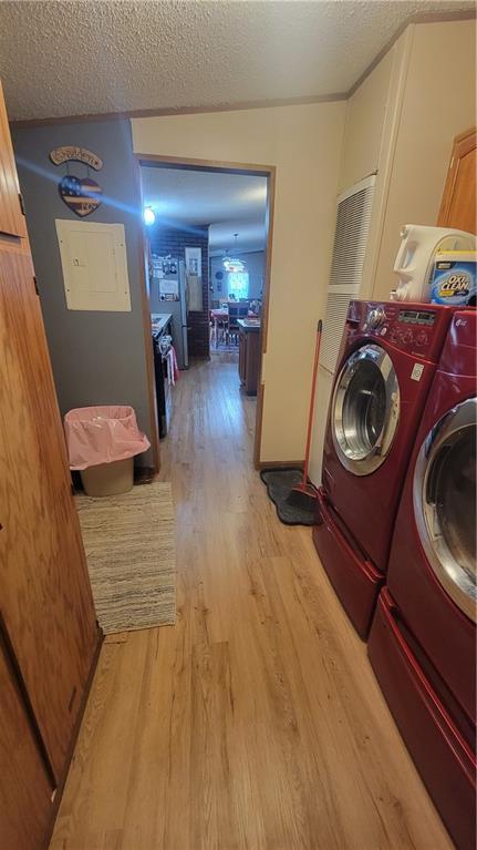 423 Elm St, Mound City, KS 66056 - washroom featuring independent washer and dryer, a textured ceiling, and light hardwood / wood-style flooring