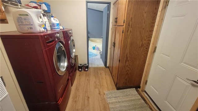 423 Elm St, Mound City, KS 66056 - laundry room with light wood-type flooring and separate washer and dryer