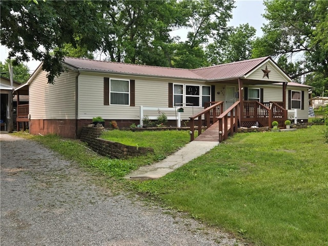 423 Elm St, Mound City, KS 66056 - view of front of house featuring a front lawn, a porch, metal roof, driveway, and crawl space
