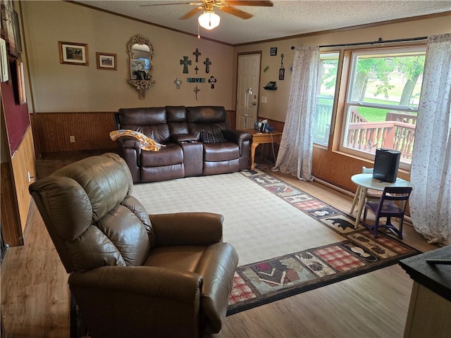 423 Elm St, Mound City, KS 66056 - living area with wood finished floors, crown molding, a ceiling fan, a wainscoted wall, and wooden walls