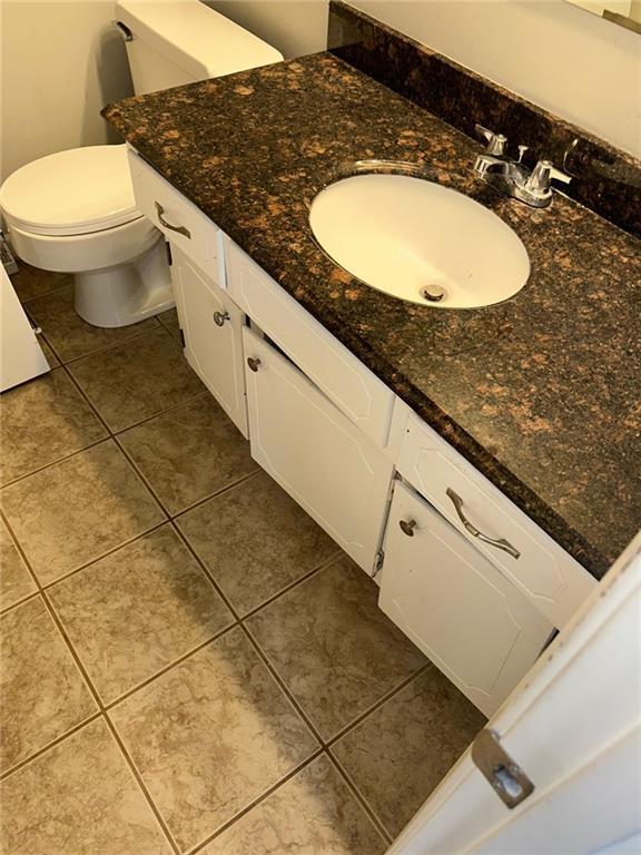 bathroom featuring toilet, tile patterned floors, and vanity