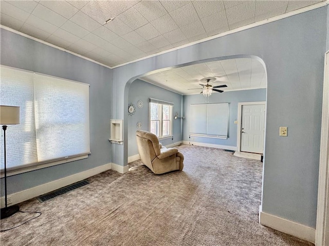 sitting room with carpet, ceiling fan, and crown molding