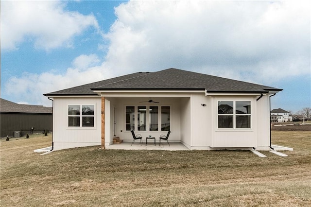 rear view of house with a patio, ceiling fan, and a lawn