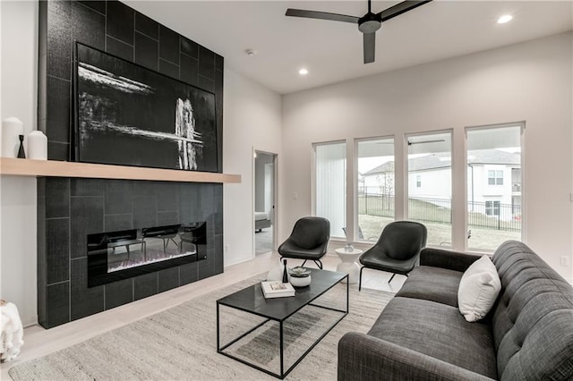 living room with ceiling fan and a fireplace