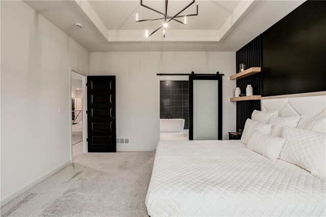 bedroom featuring a chandelier, a barn door, light colored carpet, and a raised ceiling