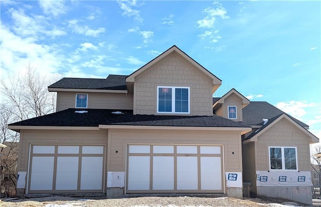 view of front of home featuring an attached garage and a shingled roof