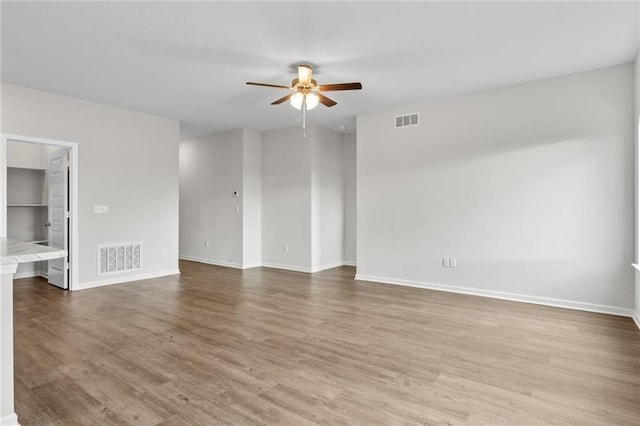 empty room with ceiling fan and hardwood / wood-style flooring