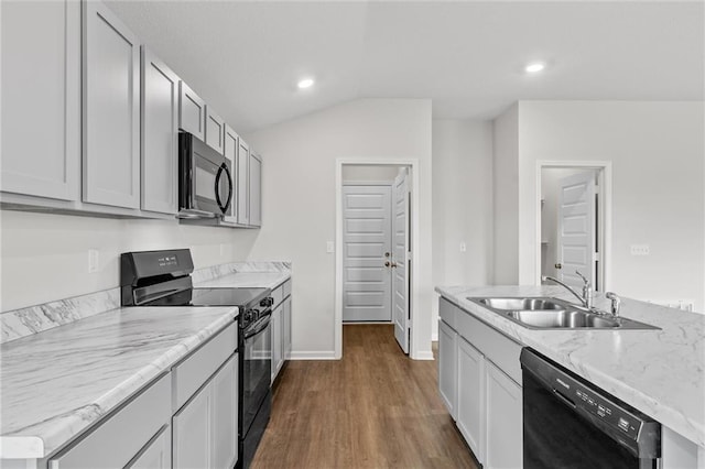 kitchen featuring light stone counters, dark wood-type flooring, black appliances, lofted ceiling, and sink