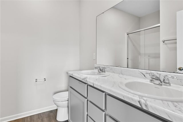 bathroom featuring toilet, walk in shower, wood-type flooring, and vanity