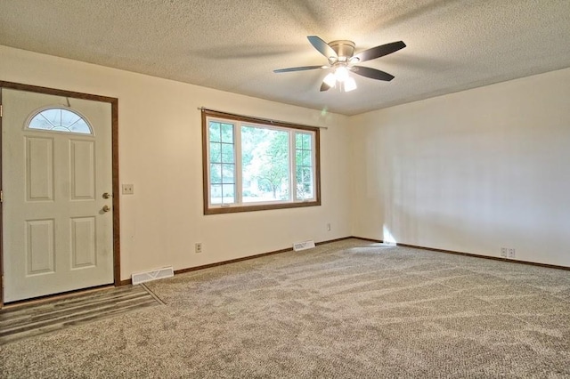 entryway with carpet, a textured ceiling, and ceiling fan