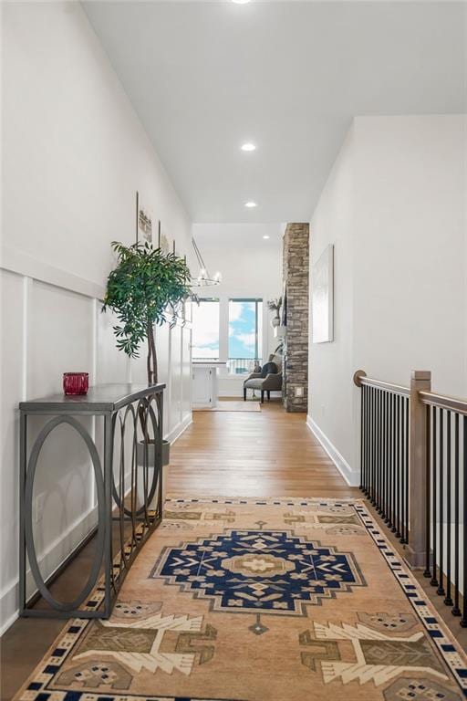 4102 W 158th Ter, Overland Park, KS 66224 - hallway with light wood finished floors, a chandelier, recessed lighting, and baseboards