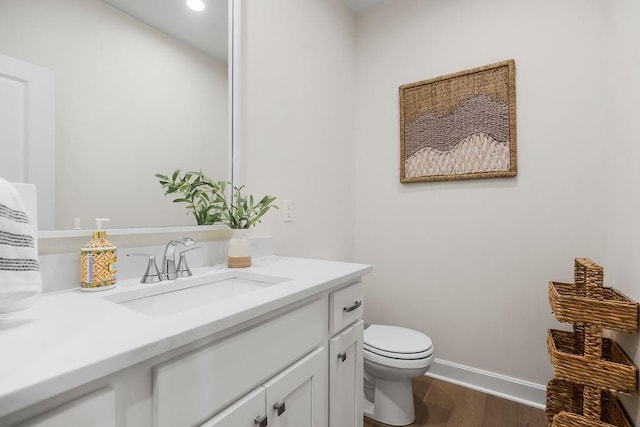 4102 W 158th Ter, Overland Park, KS 66224 - half bathroom featuring wood finished floors, toilet, vanity, baseboards, and recessed lighting