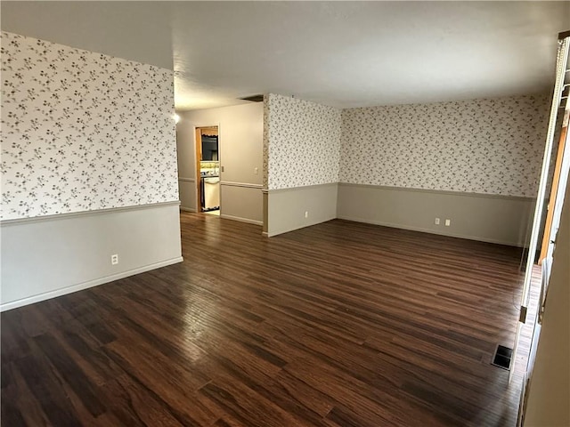 2123 N 8th St, Independence, KS 67301 - spare room with wallpapered walls, dark wood-style flooring, and a wainscoted wall