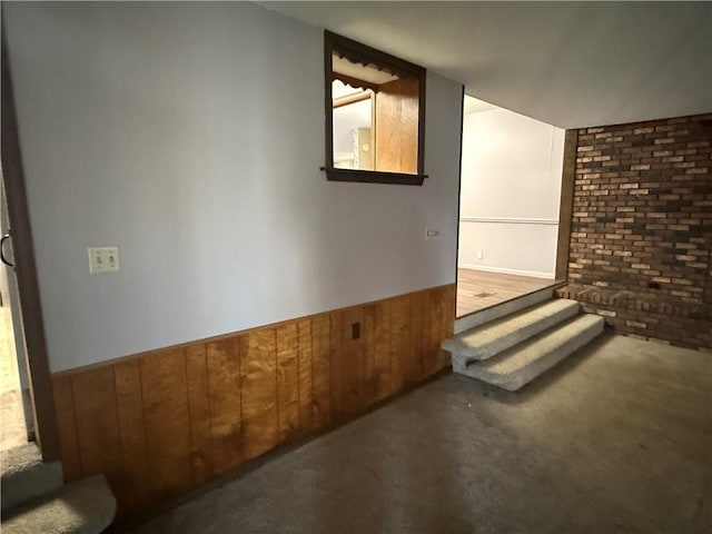 interior space with carpet flooring and wooden walls