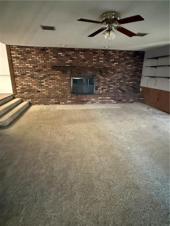 unfurnished living room featuring ceiling fan and brick wall