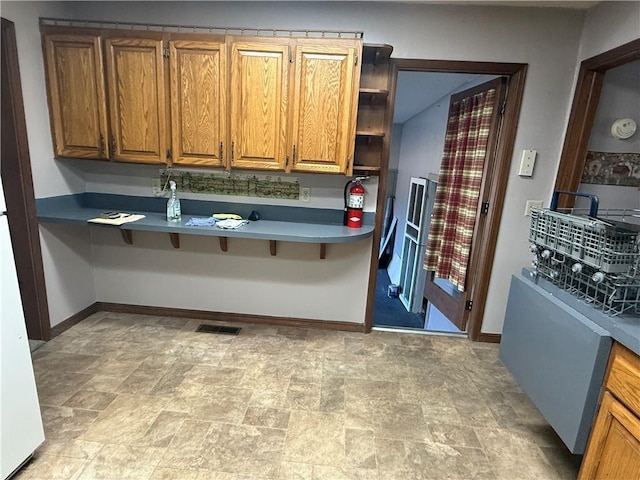 2123 N 8th St, Independence, KS 67301 - kitchen featuring open shelves, stone finish flooring, brown cabinetry, and a breakfast bar