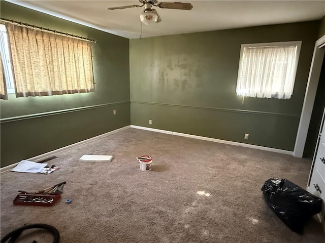 carpeted spare room featuring ceiling fan