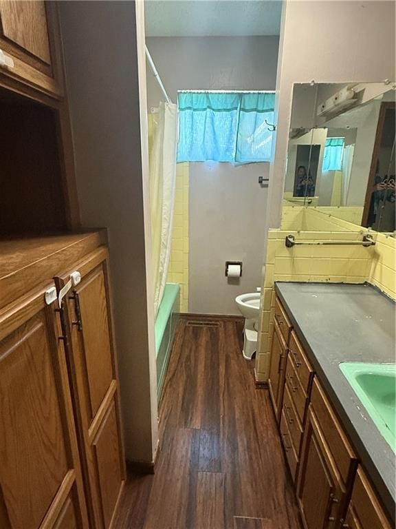 full bathroom featuring wood-type flooring, vanity, toilet, and shower / bathtub combination with curtain