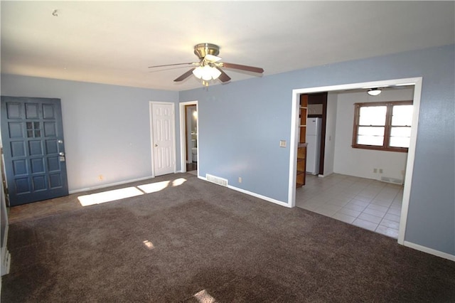 carpeted spare room featuring ceiling fan