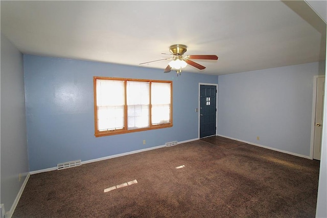 spare room with dark carpet and ceiling fan