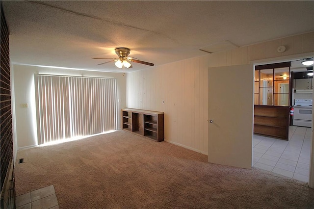 empty room featuring a textured ceiling, light colored carpet, and ceiling fan