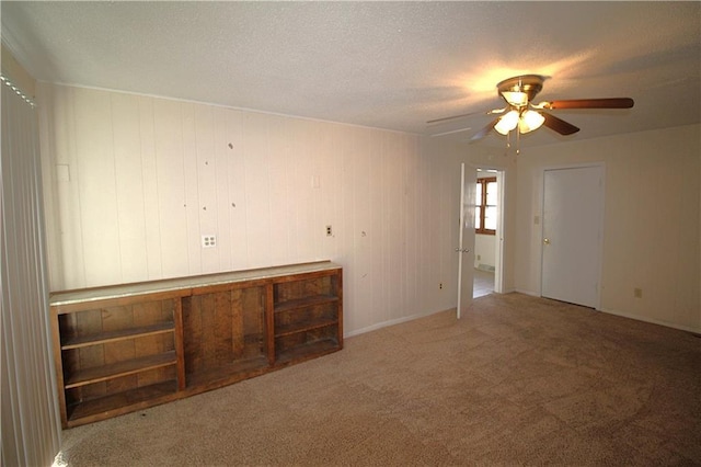 carpeted empty room with ceiling fan and a textured ceiling