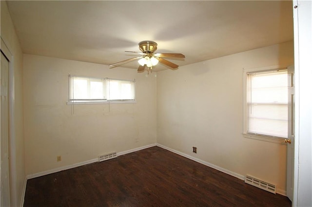 unfurnished room with dark hardwood / wood-style flooring, plenty of natural light, and ceiling fan