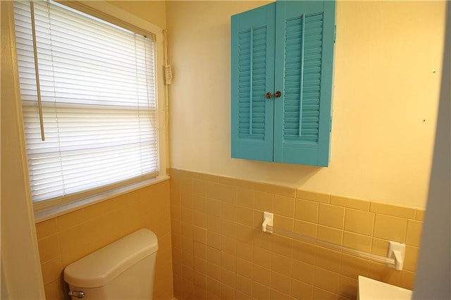 bathroom featuring toilet and tile walls