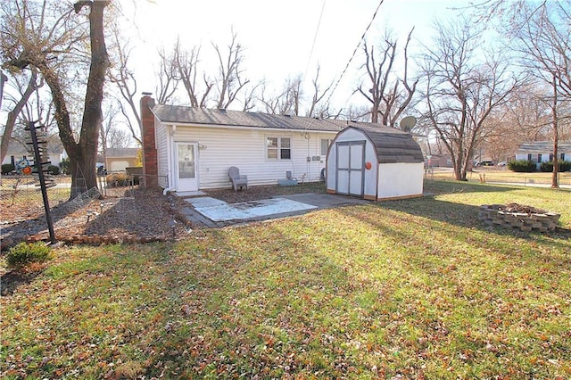 rear view of property with a yard, a fire pit, and a storage unit