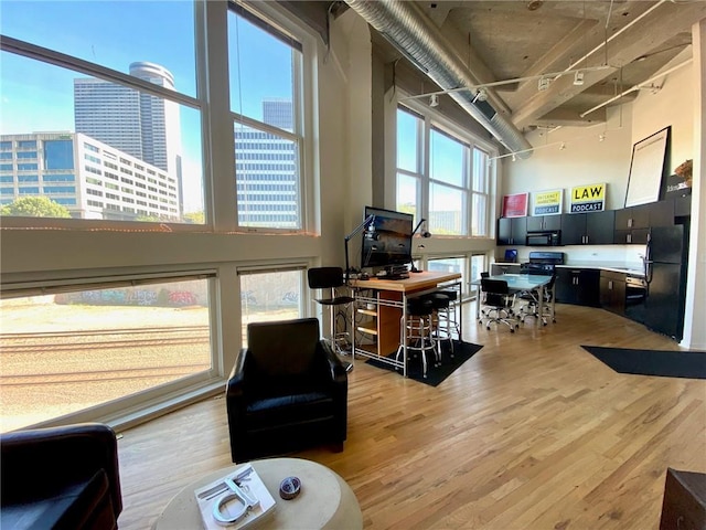 office area with plenty of natural light, a high ceiling, and hardwood / wood-style flooring