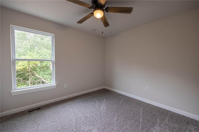 empty room featuring carpet flooring, ceiling fan, and a healthy amount of sunlight