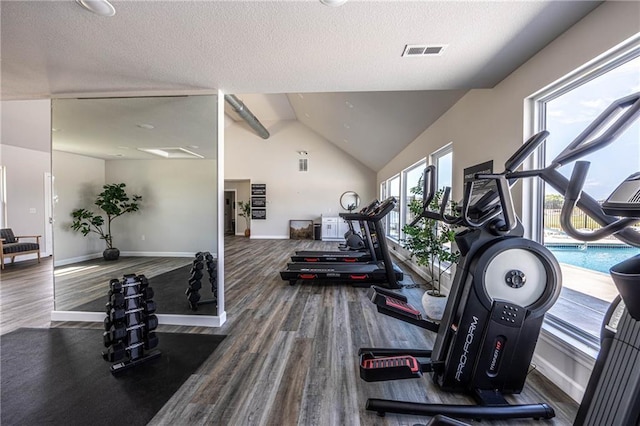 gym featuring wood-type flooring, a textured ceiling, and high vaulted ceiling