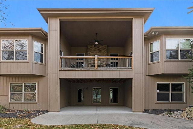 back of house with ceiling fan and a balcony