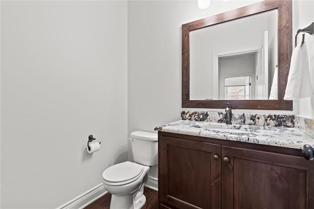 bathroom with vanity, toilet, and wood-type flooring