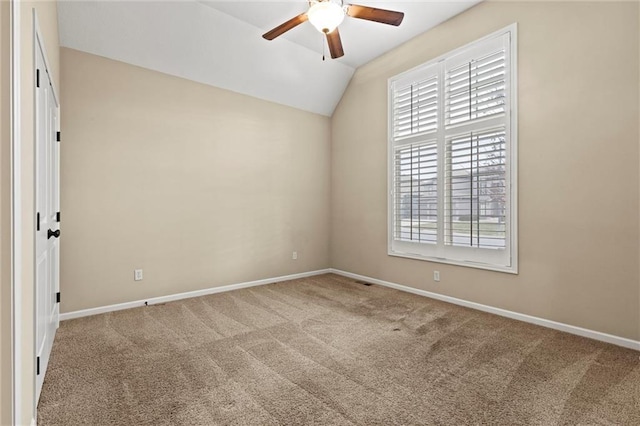 unfurnished room with carpet flooring, vaulted ceiling, ceiling fan, and a healthy amount of sunlight