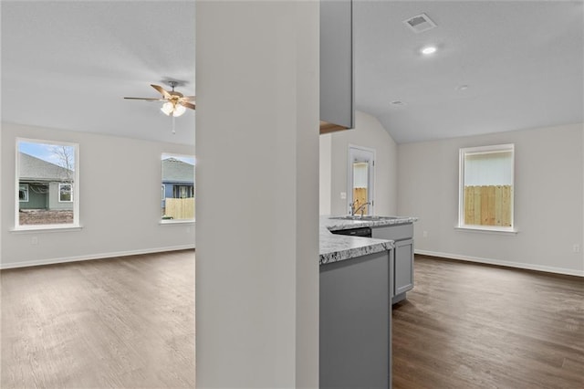 kitchen with ceiling fan, sink, dark wood-type flooring, vaulted ceiling, and gray cabinets