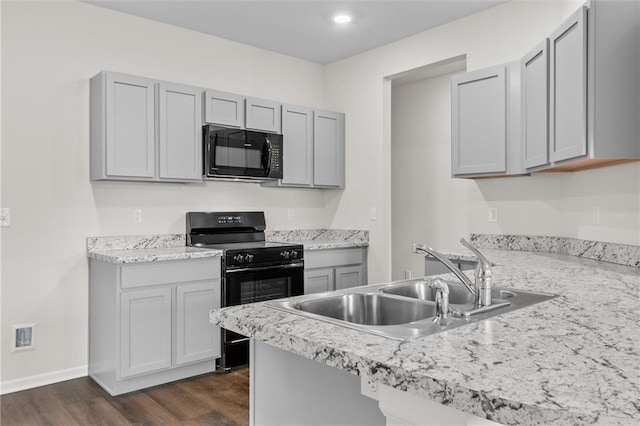 kitchen featuring black appliances, dark hardwood / wood-style floors, gray cabinets, and sink