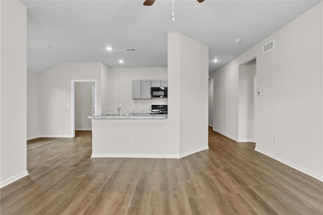 unfurnished living room with ceiling fan and hardwood / wood-style flooring